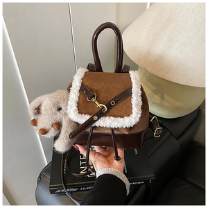 Detail of vintage patchwork leather mini backpack with sheepskin trim and elephant charm