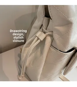 Detail of cream white quilted leather shoulder bag with drawstring closure and fine texture