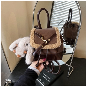 Detail of mini dark brown leather backpack with shearling trim and cute rabbit pendant