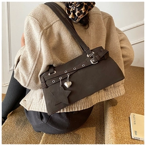 Detail of dark brown matte leather bag with silver eyelets and heart star charms