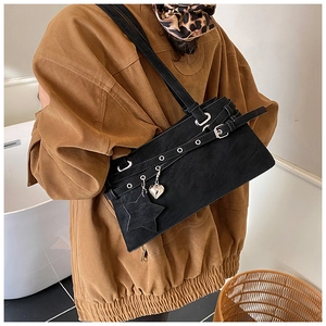 Detail of black vintage Boston bag with star charm and metallic heart on leather strap
