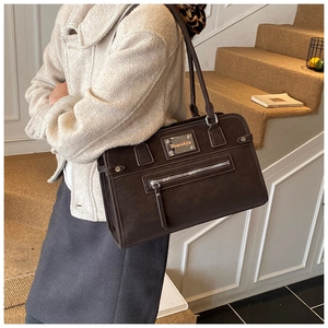 Close-up of the vintage matte suede texture and metal zipper on the large shoulder bag