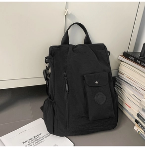 Close-up of black waterproof nylon backpack featuring a front pocket and textured fabric