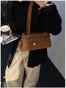 Brown suede Y2K baguette bag with star charm and metallic eyelets on street model