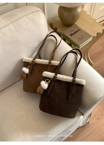 Détail d'un sac seau vintage en daim avec bordure en fausse fourrure blanche et cœur