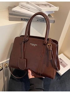 Classic dark brown glossy tote bag with adjustable shoulder strap and gold lettering