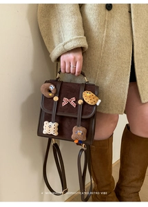 Detail of retro brown backpack with cute plush food patches and red gingham bow
