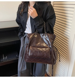 Close-up of vintage dark brown quilted tote with chain handle and drawstring detail