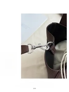 Detail shot of silver metal hooks and brown pebbled leather on a vintage bucket bag