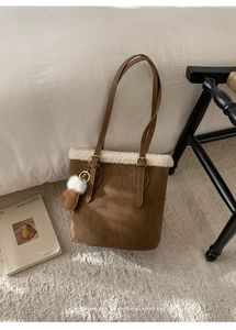 Détail du sac seau en daim avec bordure en fourrure blanche et pendentif gant créatif