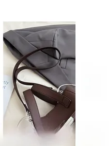 Detail of dark brown lychee leather texture and silver twist lock on bucket bag