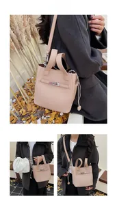 Detail of beige lychee leather bucket bag with silver turn-lock and drawstring insert