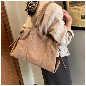 Détail des rivets vintage et des anneaux en argent sur un grand sac cabas