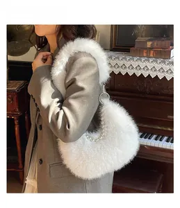 Détail du sac croissant en fausse fourrure blanche avec chaîne perlée et bandoulière peluche