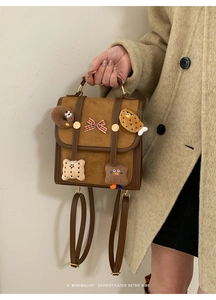 Detail of retro color-block backpack with cute cartoon pins and red plaid bow decoration