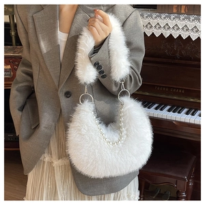 Détail du sac à main en fausse fourrure blanche avec chaîne en perles et boucle argent