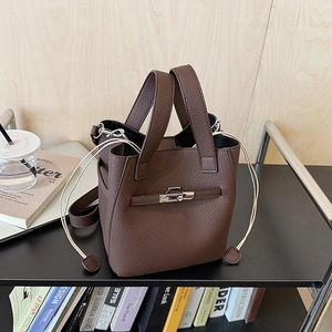 Detailed macro view of the dark brown lychee grain leather texture and silver metal lock
