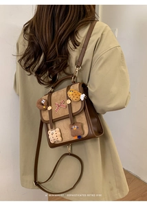 Retro brown flap backpack with cute 3D cartoon patches shown from a back view