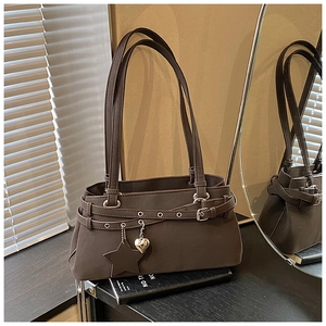 Detail of dark brown retro shoulder bag with matte leather and metal star pendants