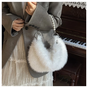 Détail du sac en fausse fourrure blanche avec une anse élégante en perles et anneau doré