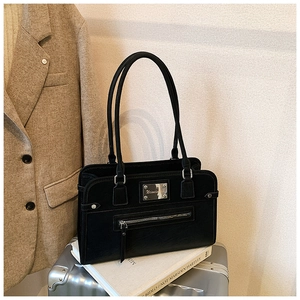 Close-up of black matte faux leather tote bag with silver metal logo and zip detail