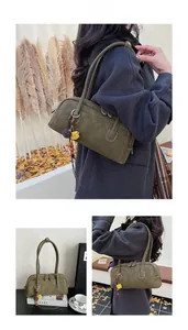 Detail of olive green vintage leather bag with metal buckle, tassel and colorful pompom