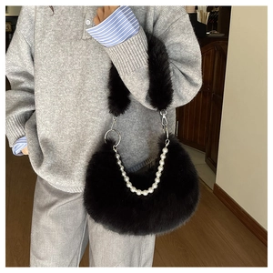 Détail du sac croissant en fausse fourrure noire avec chaîne perlée et bandoulière