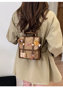 Retro brown suede backpack with cute plush patches and bow detail shown on model