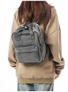 Details des grauen Rucksacks aus gewaschenem Denim mit Fronttasche und Tragegriff