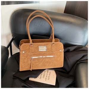 Detail of a brown textured faux leather Boston bag with silver zipper and logo plaque