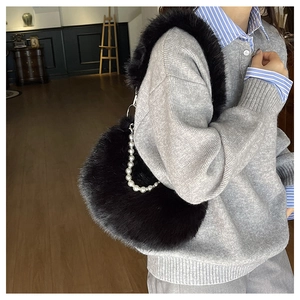 Sac à main chic en fausse fourrure noire avec chaîne perlée porté avec une tenue décontractée