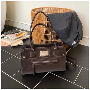 Detailed view of dark brown vintage matte PU leather shoulder bag with metallic branding