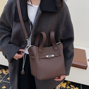 Brown litchi leather bucket bag with silver turn-lock and adjustable shoulder strap