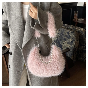 Détail du sac croissant en fausse fourrure rose avec chaîne de perles et anse douce