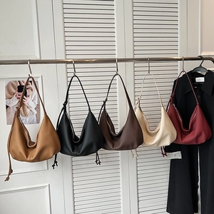 Detailed display of five minimalist PU leather hobo bags hanging in neutral trendy colors