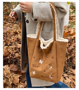 Dettaglio borsa tote in pelle scamosciata caramello con ricamo e bordo in pelliccia