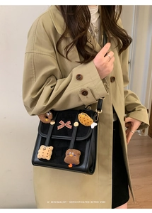 Detail of retro black shoulder bag with cute cartoon food plush charms and bow