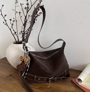 Detail of vintage brown tote bag with contrast stitching and leopard bow accessory
