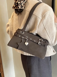 Minimalist chocolate suede Boston bag with star charm worn by model in tweed jacket