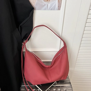 Detailed view of dark red crescent shoulder bag with smooth matte leather texture