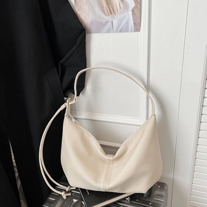 Detail shot of the cream hobo bag with a knotted strap and litchi-grain leather texture