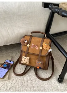 Retro brown plush backpack featuring cute food patches and red plaid bow on soft carpet