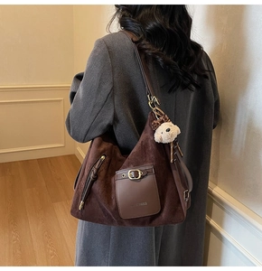 Detail of hobo bag with Just Paris metal buckle and plush bear pendant detail