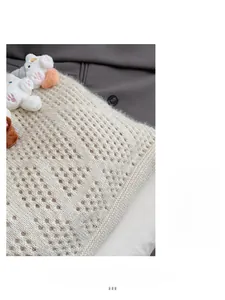 Detailed knit texture of a beige tote bag featuring cute mini plush cat ornaments