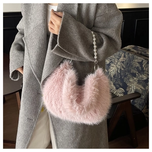 Vue détaillée du sac à main en peluche rose avec poignée en perles blanches sur manteau