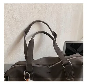 Detailansicht der braunen Leder-Tragetasche mit robusten Griffen und Metallreißverschluss