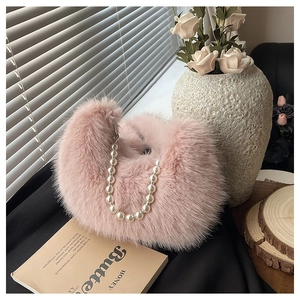 Détail du sac croissant en fausse fourrure rose avec une poignée luxueuse en perles
