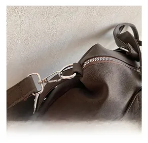 Nahaufnahme hochwertiger silberner Metallhaken und Reißverschlüsse an brauner Tasche