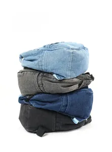 Detailansicht gestapelter gewaschener Denim-Rucksäcke in Blau, Dunkelblau, Grau und Schwarz