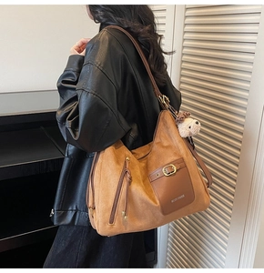 Detail view of large brown suede tote with MKCH PARIS logo and plush dog charm